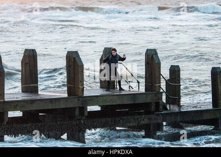 Aberystwyth Wales UK, giovedì 23 Feb 2017 UK Meteo: Ragazzi sul pontile in Aberystwyth giocando un gioco rischioso di schivare le onde all indomani della tempesta Doris era il quarto denominato storm dell'inverno ed è stato classificato come un "meteo bomba' (esplosiva cyclogenesis) dal Met Office Photo credit: keith morris/Alamy Live News Foto Stock