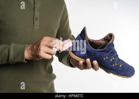 L'uomo la sua pulizia scarpe scamosciate, cura delle calzature Foto Stock