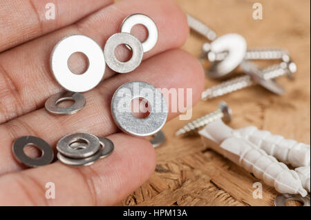 Closeup mucchio di vite tampone la rondella in mano Foto Stock