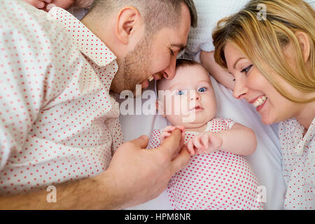 Il padre e la madre con bambino sorridente giacente Foto Stock