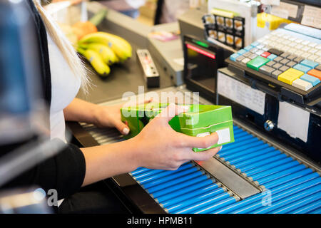 Immagine ritagliata della femmina di scansione del cassiere juice pack per il codice a barre nel supermercato Foto Stock