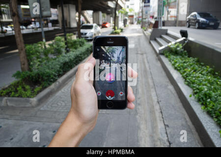 Bangkok, Tailandia - 22 Febbraio 2017 : Apple iPhone5s tenuto in una mano che mostra il suo schermo con Pokemon Go. Foto Stock