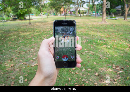 Bangkok, Tailandia - 22 Febbraio 2017 : Apple iPhone5s tenuto in una mano che mostra il suo schermo con Pokemon Go. Foto Stock