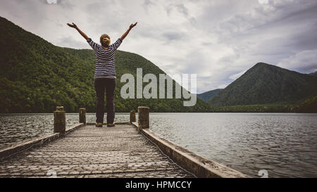 La ragazza si è levato in piedi nel timore reverenziale al Lago Daniell Jetty Foto Stock