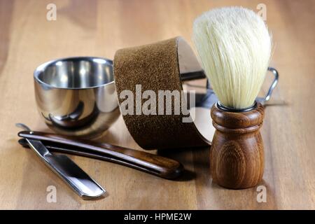 Rasoio con accessori su sfondo di legno Foto Stock