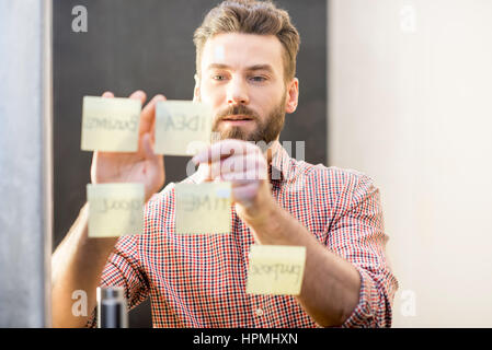 Uomo al lavoro con adesivi sulla porta Foto Stock