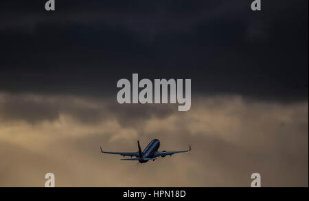 Un aereo decolla dall'aeroporto di Leeds Bradford in cloud pesanti come i voli sono stati annullati e pendolari sono stati avvertiti che hanno affrontato i ritardi dopo la tempesta Doris ha raggiunto quasi 90mph sul suo modo di pastella Gran Bretagna. Foto Stock