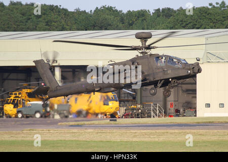 AAC Apache di atterraggio sulla pista Wattisham durante la pratica del circuito. L'ora in disuso la ricerca e il salvataggio hangar può essere visto dietro. Foto Stock