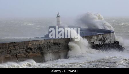 Onde infrangersi sopra il faro in Newhaven, East Sussex, in quanto i voli sono stati annullati e pendolari sono stati avvertiti che hanno affrontato i ritardi dopo la tempesta Doris ha raggiunto quasi 90mph sul suo modo di pastella Gran Bretagna. Foto Stock