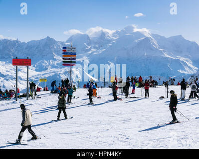 Gli sciatori a Les Grandes Platieres in Le Grand Massif ski area con vedute di nevato Mont Blanc e montagne nelle Alpi francesi. Flaine Francia Foto Stock