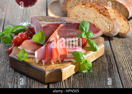 Sud speck tirolese con fresco forno in pietra cotto il pane e il vino rosso locale Foto Stock