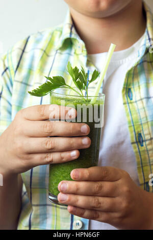Bambino (boy) potabile verde sano frullato vegetale - mangiare sano, vegano vegetariano, cibo organico e concetto di bevanda Foto Stock