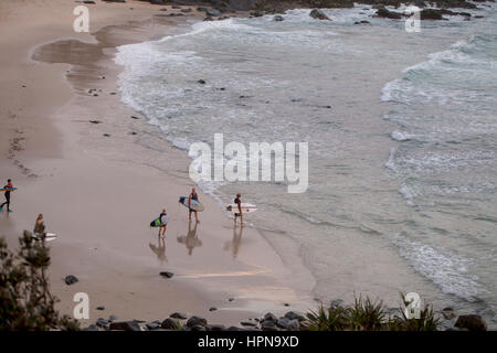 Cabraritta Beach, Australia - 31 dicembre 2015. Surf. Una famiglia di surfisti sono voce fuori per un inizio di mattina surf come il sole sorge. Il reflecte Foto Stock