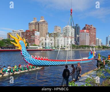 KAOHSIUNG, Taiwan - 27 Maggio 2016: una gru si abbassa di un dragon boat nel fiume dell'amore in preparazione per la prossima Dragon Boat Festival. Foto Stock