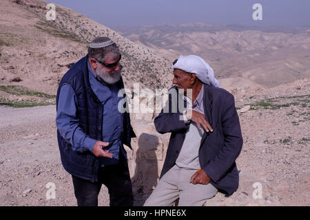 Gadi Kopel un sedimentatore ebraico e uno dei fondatori dell'insediamento ebraico di Mitzpe Yeriho situato a est di Gerusalemme che parla con beduina uomo della tribù Jahalin in un punto di osservazione vicino a Mitzpe Yeriho affacciato sul Judaean o deserto della Giudea in Cisgiordania. Foto Stock