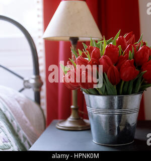 Una benna di tulipani su un comodino. Foto Stock