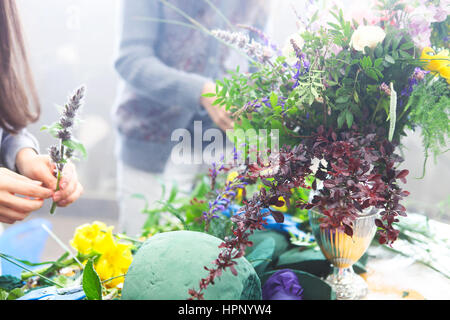 Fioraio donna decorazione di bouquet di fiori Foto Stock