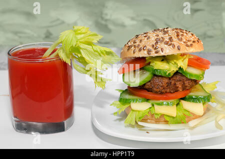 Grande Burger e succo di pomodoro con sedano in vetro. Foto Stock