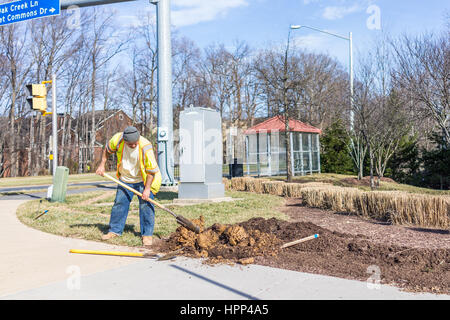 Fairfax, Stati Uniti d'America - 18 Febbraio 2017: lavoratore terreno di scavo nel terreno per paesaggistica Foto Stock