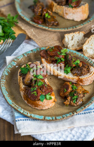 Fegato di pollo e il chorizo sandwich aperto guarnite con prezzemolo fresco Foto Stock