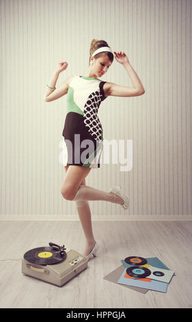 Giovane donna dancing at home, stile 1960 Foto Stock