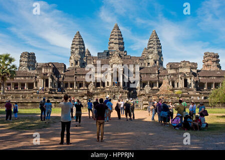 La folla e i gruppi di turisti a piedi o prendendo fotografie presso la porta est di Angkor Wat in Cambogia, vicino a Siem Reap. Foto Stock
