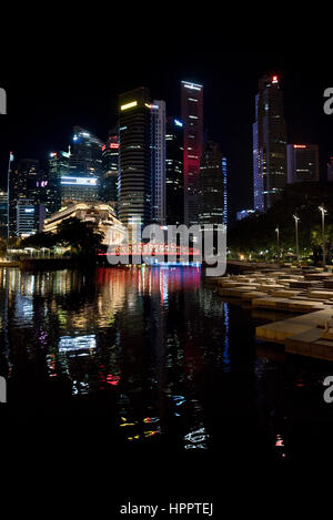 Il Quartiere Centrale degli Affari di Singapore si riflette nell'acqua della baia di Marina di notte. Foto Stock