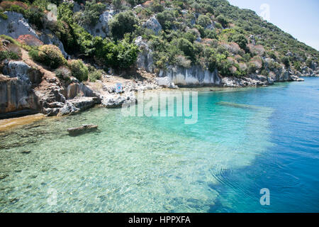 Città Sommersa di kekova nella baia di uchagiz vista dal mare in provincia di Antalya in Turchia con turqouise rocce del mare e il verde delle boccole con resti di antichi Foto Stock