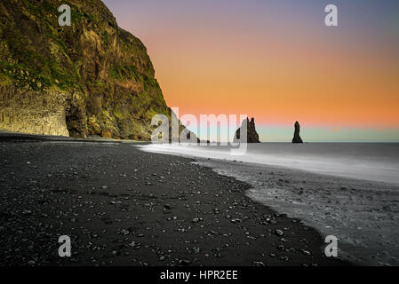 La spiaggia di sabbia nera di Reynisfjara e il monte Reynisfjall vicino al villaggio di Vik nel sud dell'Islanda. Lunga esposizione. Foto Stock