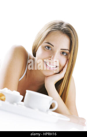Giovane bella donna avente la colazione a letto. Foto Stock