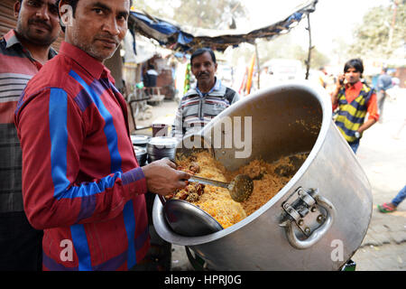 Un fornitore Biryani servono pollo Biryani dal suo pot in Kannauj, Uttar Pradesh, India. Foto Stock