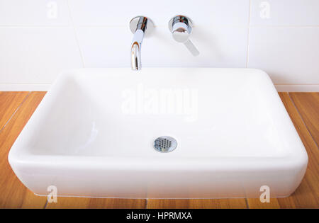 Porcellana Bianca lavabo e cromati rubinetti in bagno. Foto Stock