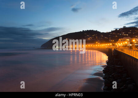 Dunedin, Otago, Nuova Zelanda. Vista lungo gli illuminati spianata per Forbury Hill al crepuscolo, St Clair, luci riflesse nell'Oceano Pacifico. Foto Stock