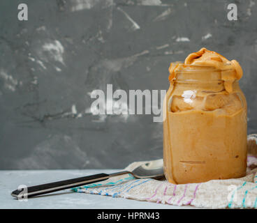 Colazione casalinga gelato alla banana con burro di arachidi nel vaso del frullatore. Amore per un sano cibo vegan concept Foto Stock