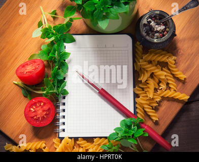 Vista dall'alto di un vuoto ricettario circondato di ingredienti alimentari Foto Stock