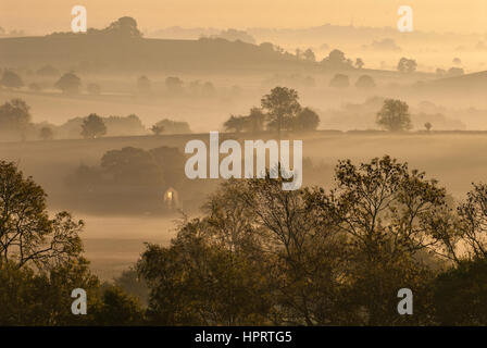 In Vista aprire il rotolamento terreno agricolo in una nebbiosa mattina di autunno prese dal B4035 road vicino Tadmarton, Oxfordshire, Inghilterra, Regno Unito. Foto Stock