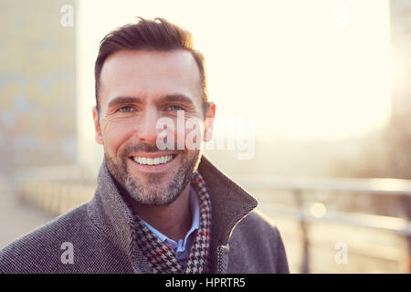 Ritratto di felice uomo sorridente all'aperto durante l'inverno freddo giorno Foto Stock