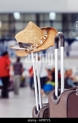 Bagagli con cappello di paglia al terminal aeroportuale Foto Stock