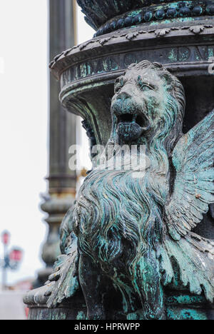 Un scolpito leone alato su un lampione a Venezia, Italia Foto Stock