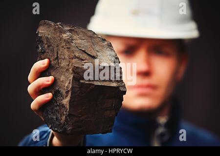 Il lavoratore che mostra la lignite - spesso indicato come carbone marrone Foto Stock