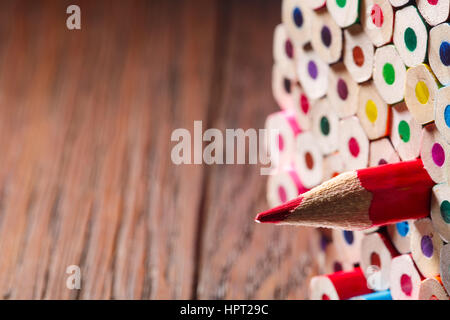 Pack di matite a colori con un unico forte uno che simboleggia il concetto di leadership e approccio unico in piedi fuori dalla folla di elementi del gruppo. Legno bro Foto Stock