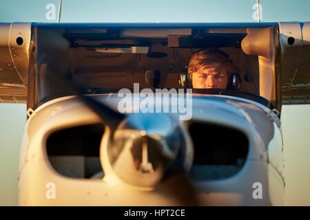 Giovane pilota si sta preparando per il decollo con aereo privato. Foto Stock