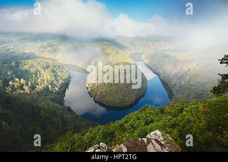 Vista sulla valle del fiume nella nebbia mattutina. Il fiume Moldava nella Boemia centrale, Repubblica Ceca. Foto Stock