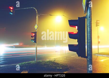 Semaforo - bivio nella notte di nebbia Foto Stock