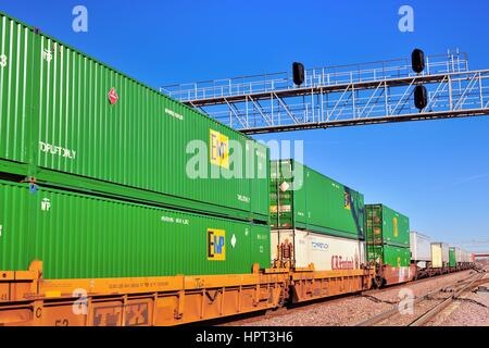 Un westbound Union Pacific treno di unità di linea di merci containerizzate Trasporto fuori di Chicago passando sotto un segnale torre in Elburn, Illinois, Stati Uniti d'America. Foto Stock