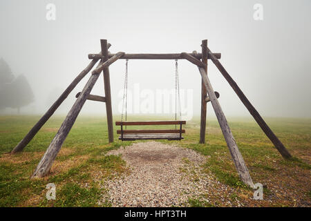 La solitudine - swing vuota nella nebbia misteriosa Foto Stock