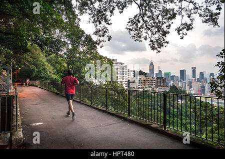 BOWEN ROAD, ISOLA DI HONG KONG - Settembre 2013 - un pareggiatore e dog walker su strada di Bowen, alta al di sopra dell'Isola di Hong Kong. Il Central Plaza grattacielo può essere s Foto Stock