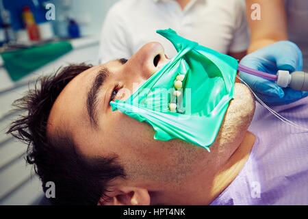 Studio dentista - giovane uomo nella poltrona del dentista Foto Stock