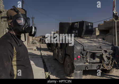 A Mosul, governatorato di Ninive, Iraq. Il 23 febbraio, 2017. Un esercito iracheno soldato in una maschera a gas per le strade di Mosul. Credito: Berci Feher/ZUMA filo/Alamy Live News Foto Stock