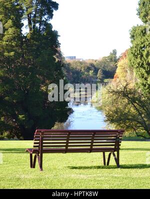 Svuotare una panchina nel parco su una collina erbosa nel parco Foto Stock